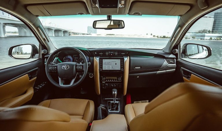 Intérieur du Toyota Fortuner, spacieux et moderne, avec un tableau de bord élégant et des sièges confortables